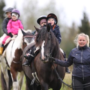 Små barn som rider på hästar