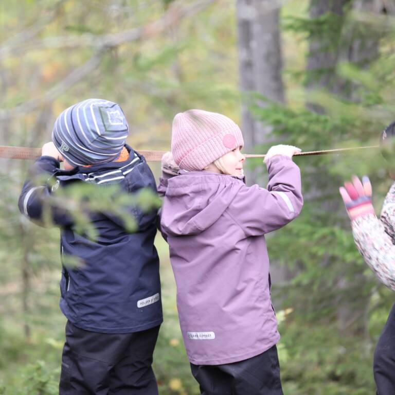 Barn som går balansgång i skogen