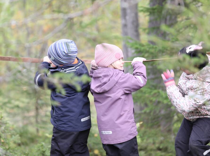 Barn som går balansgång i skogen